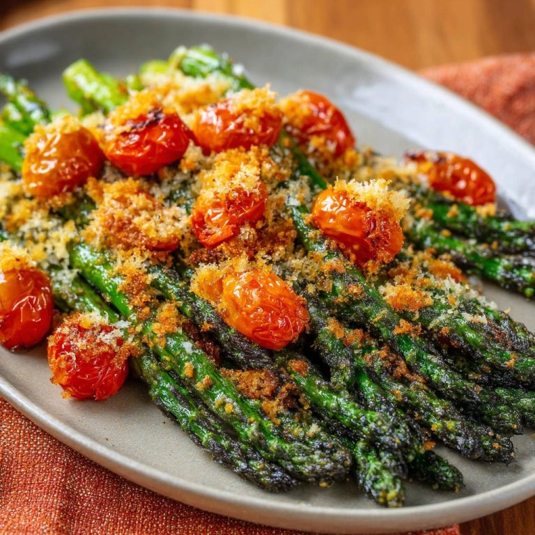 Grüner Spargel mit Kirschtomaten und Knusper-Topping, Nahaufnahme der knusprigen Textur und der gebratenen Tomaten.