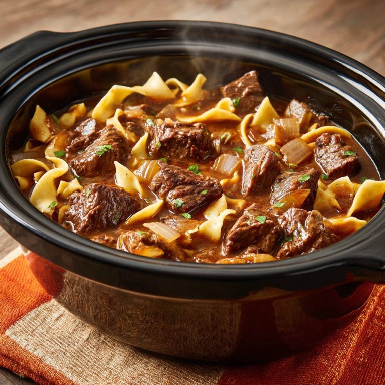 Zarter Rinder-Topf mit Bandnudeln dampfend im Slow Cooker, Nahaufnahme der zarten Fleischstücke und Nudeln.