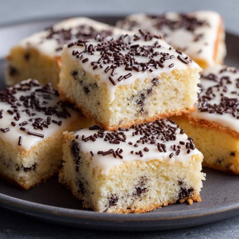 Schoko-Sprenkel-Kuchen mit glasierten und bestreuten Stückchen auf einem Teller, Nahaufnahme des Anschnitts.