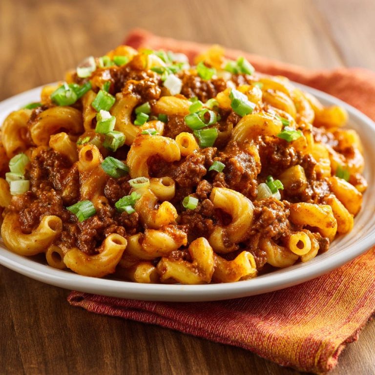 Macaroni mit deftiger Hackfleischsoße, serviert auf einem Teller und garniert mit frischen Frühlingszwiebeln.