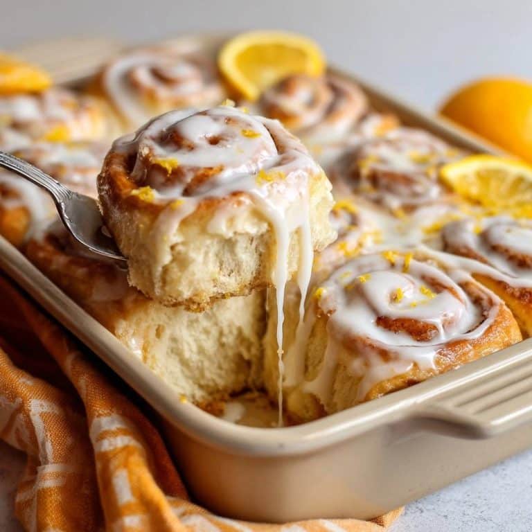 Zitronen-Brioche-Schnecken angeschnitten mit viel Glasur, die von einer einzelnen Schnecke tropft.