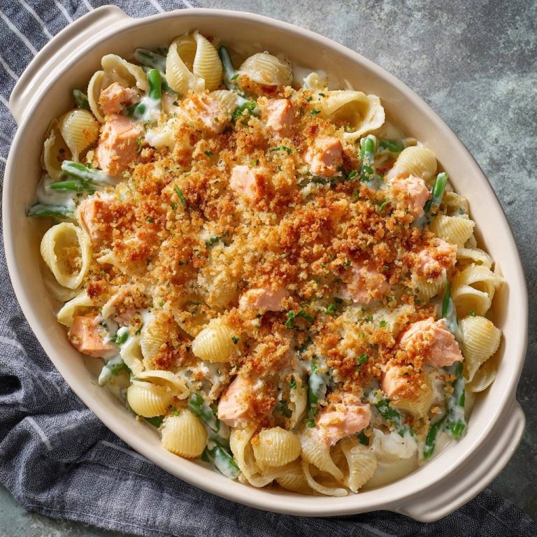 Cremiger Lachs-Conchiglie-Auflauf mit grünen Bohnen von oben mit knusprigem Topping aus der Auflaufform.