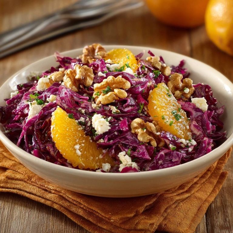 Rotkohl-Orangen-Salat mit Walnuss und Feta, Nahaufnahme der Zutaten und garniert mit Orangenspalten und Nüssen.