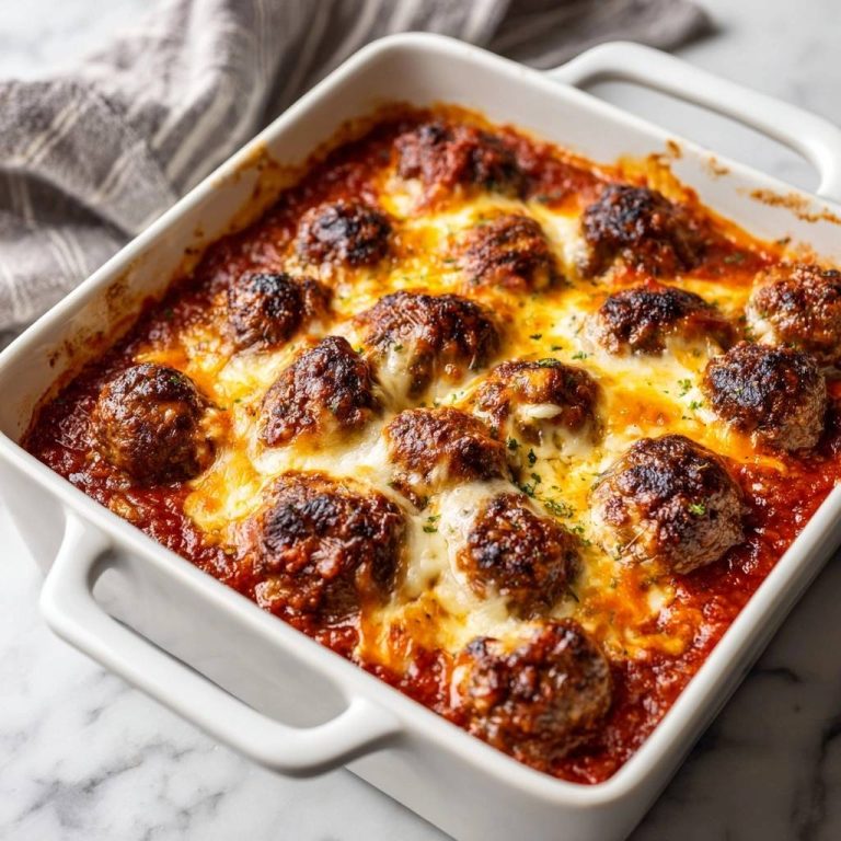 Saftiger Frikadellenauflauf mit Käse im weißen Auflaufform, frisch aus dem Ofen gebacken
