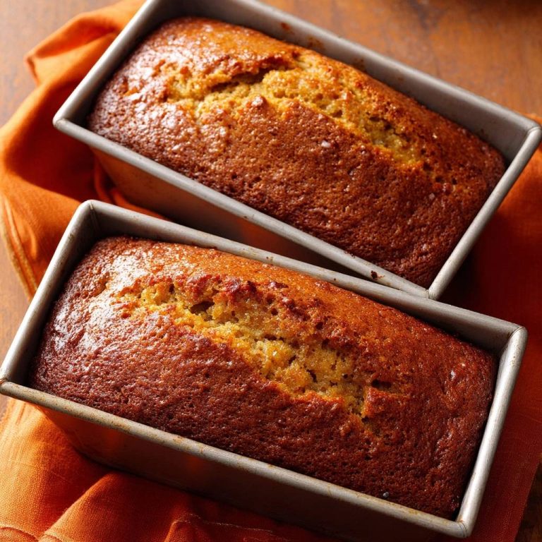 Saftiges Bananenbrot frisch gebacken in zwei Metall-Kastenformen auf einem orangen Tuch liegend