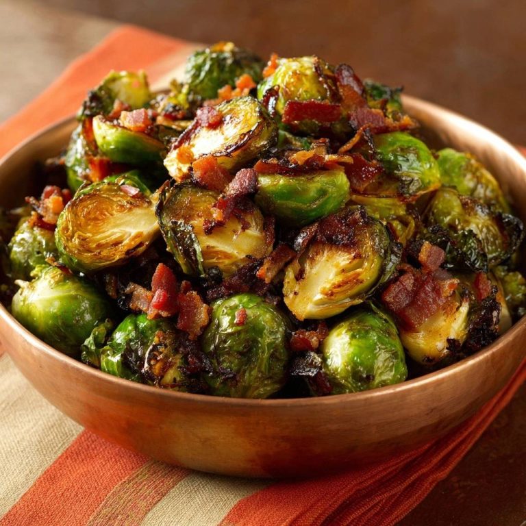Gerösteter Rosenkohl mit Bacon, Anschnitt zeigt die zarte Innenseite und knusprige Speckstücke in einer Kupferschüssel.