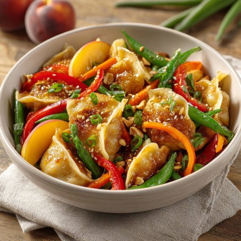 Knusprige Dumpling-Pfanne mit Pfirsich und Paprika, Nahaufnahme der goldbraunen Dumplings mit Gemüse und Pfirsichstücken.