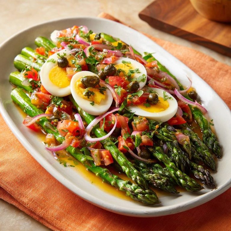 Mediterraner Spargelsalat mit Ei, nahaufnahme der Spargelspitzen mit Eischeiben und Tomaten-Vinaigrette garniert.