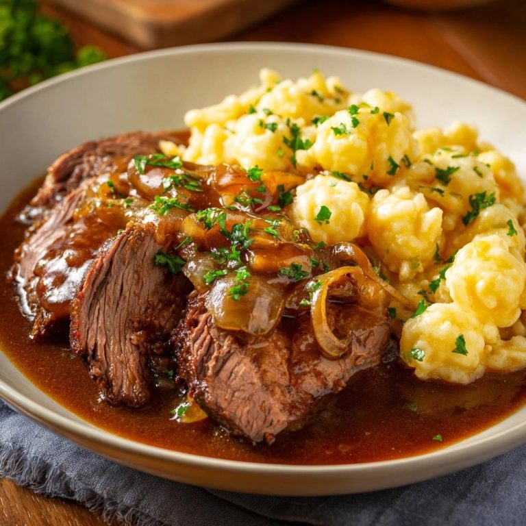 Zarter Rinderbraten mit Spätzle, nahaufnahme des saftigen Fleisches mit Zwiebelsoße und garniert mit Petersilie.